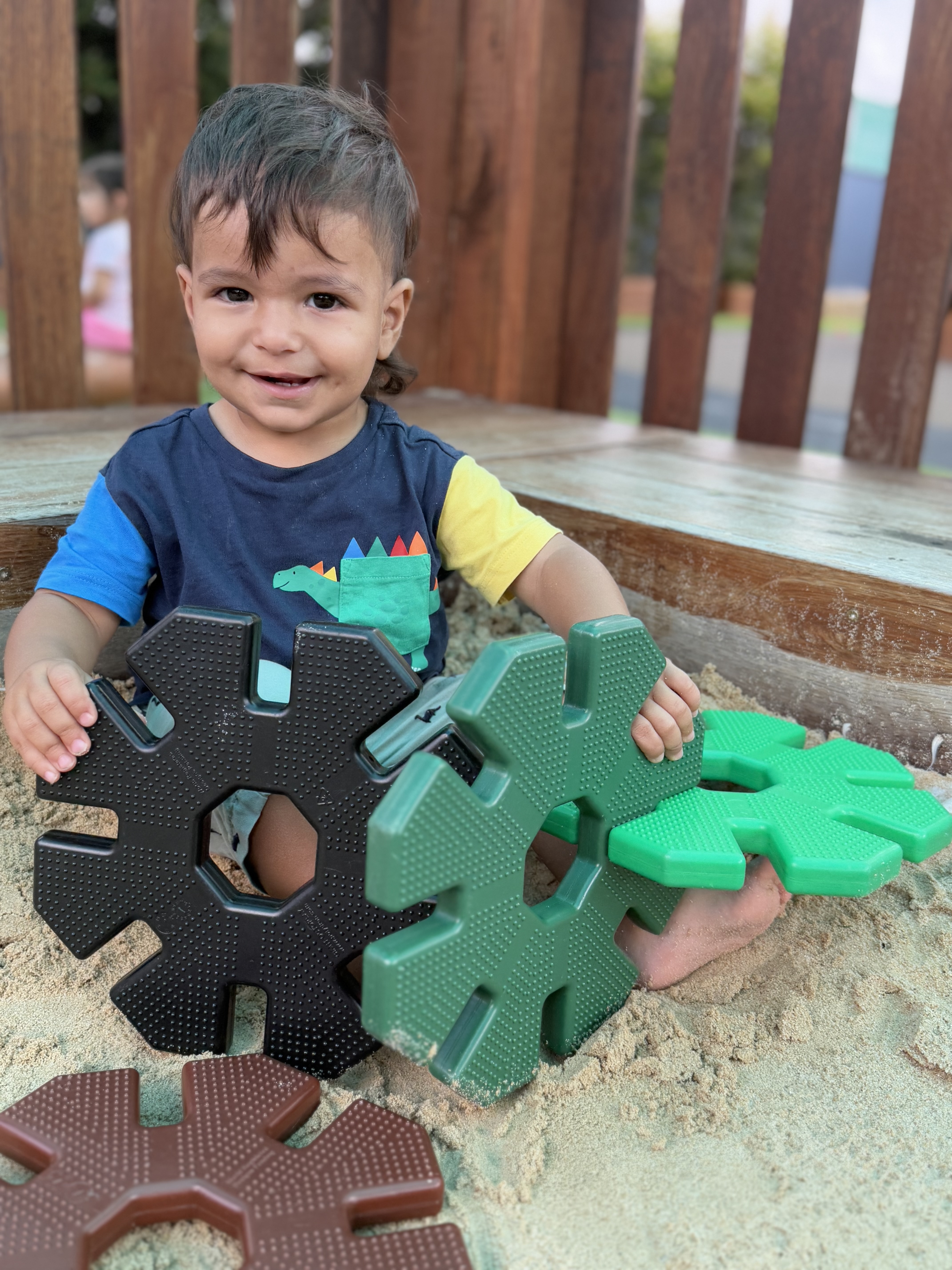 Child outdoors putting a big puzzle together